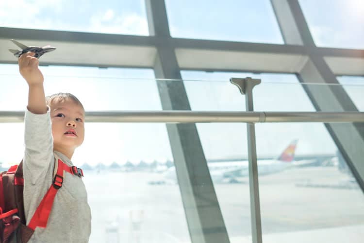 little boy playing with airplane in an airport