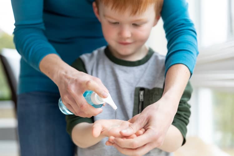 boy using hand sanitizer