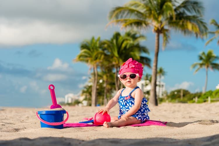 baby girl playing in sand at one of the best all-inclusive family resorts in the us