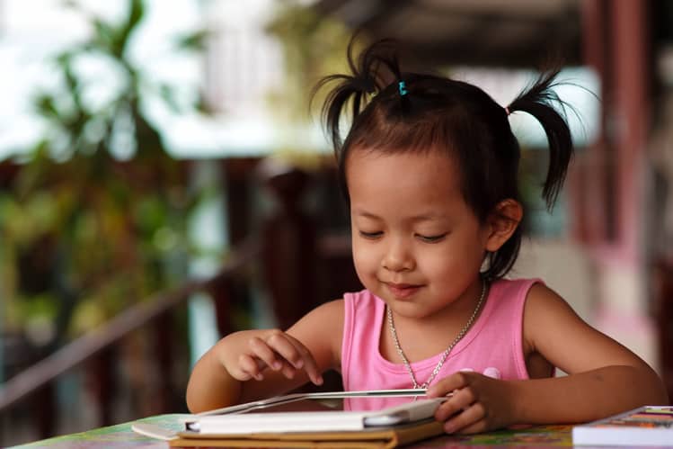 {UPDATED} Pros & Cons of Screen Time for Small Kids 2 girl playing tablet on family vacation