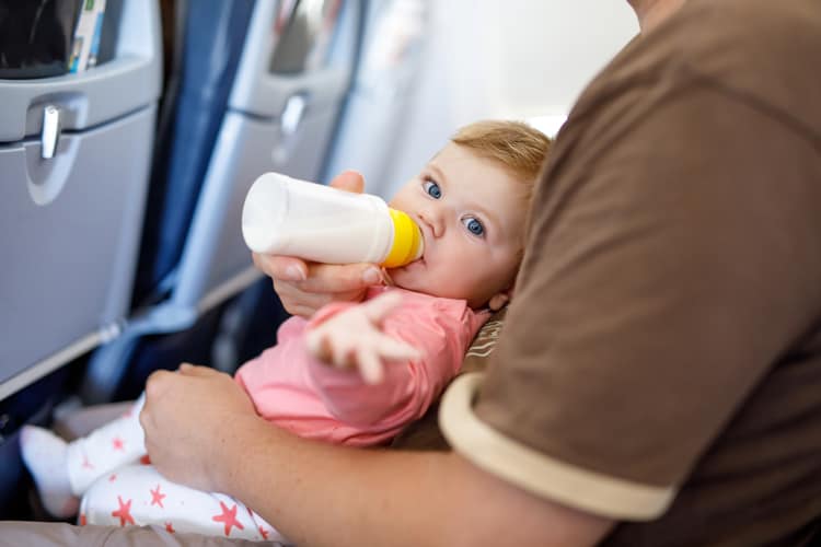 {Updated} 14 Tips For Stress-Free Flying With Babies And Toddlers 15 Baby Drinking Bottle On Airplane During Stress-Free Flying With Babies And Toddlers
