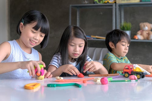 Staycation Ideas for Babies and Toddlers 5 kids playing play-doh during a staycation