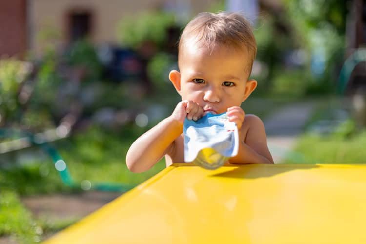 baby eating a squeeze applesauce pouch