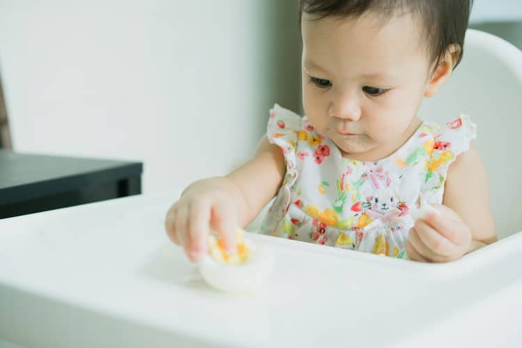 baby eating hard boiled egg
