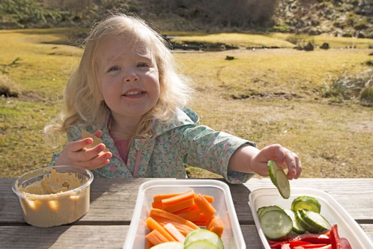 girl eating hummus in the park