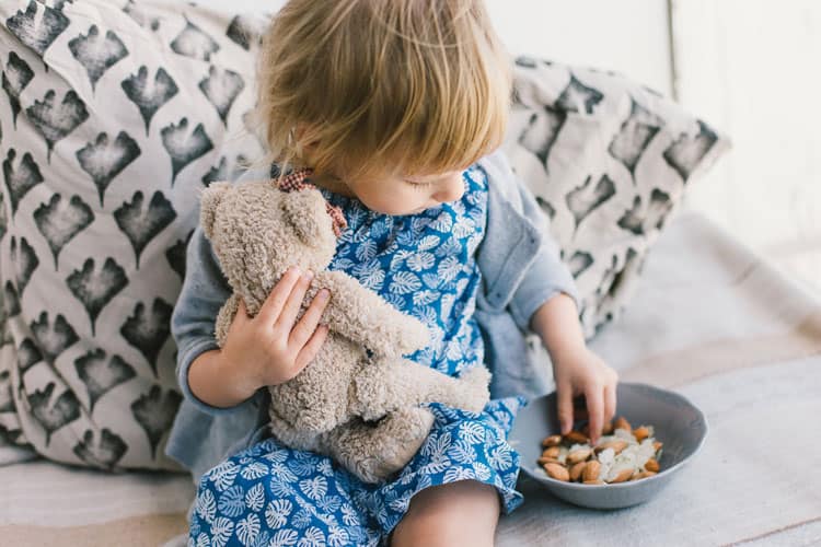 child eating nuts from a bowl