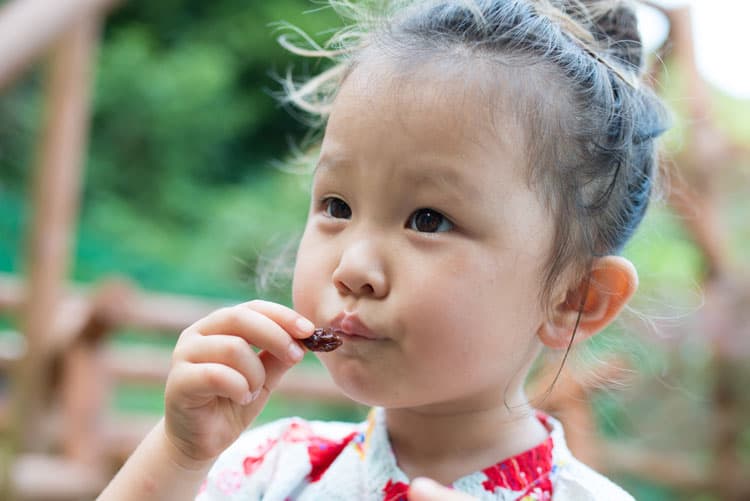 asian girl eating a raisin