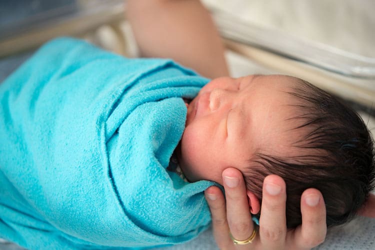 12 Essential Baby Registry Must Haves 3 baby wrapped in a swaddle blanket
