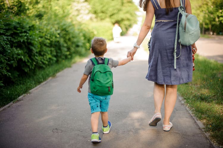 How to Help Your Child With Back-to-School Anxiety 8 boy walking to kindergarten with his mom