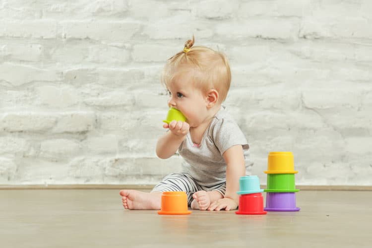 {UPDATED} Is My Baby Teething? 3 baby with toy in her mouth