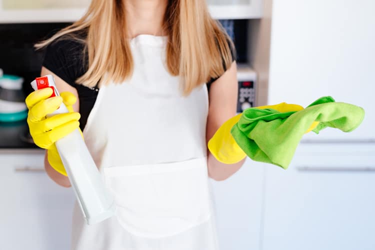 woman holding cleaning products