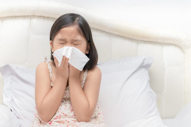 What To Clean When Your Child Is Sick 2 Child Sneezing Into A Tissue