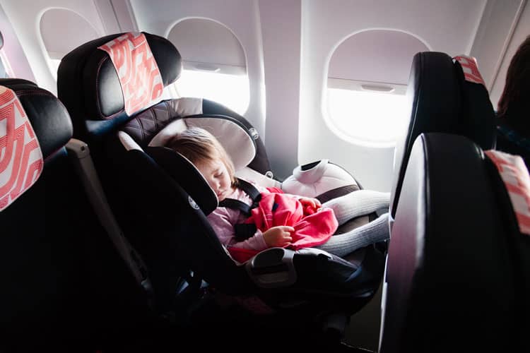 Flying With a Newborn: 10 Ways to Make it Easier 4 baby sleeping in a car seat in an airplane