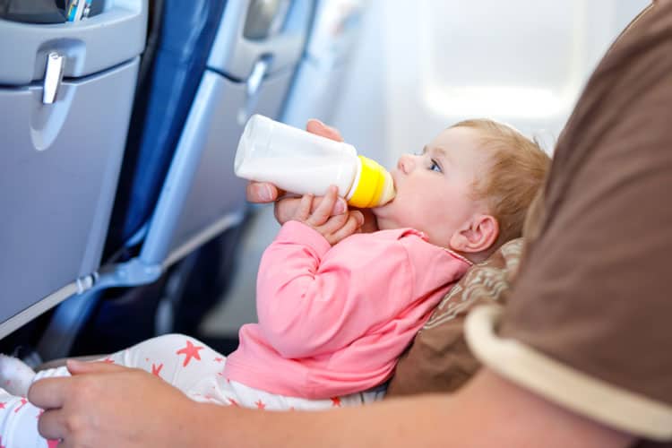 Flying With a Newborn: 10 Ways to Make it Easier 9 baby drinking bottle on airplane