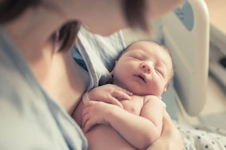 Flying With a Newborn: 10 Ways to Make it Easier 2 woman holding her newborn