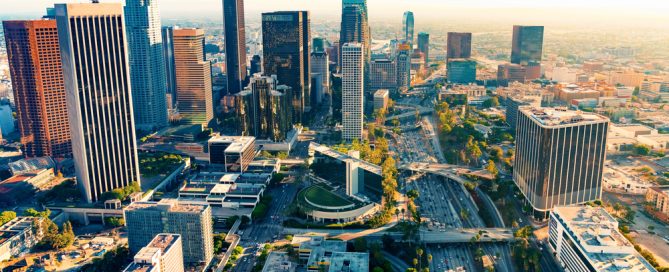 Aerial View Of Los Angeles Cityscape Featuring Tall Buildings And Busy Highways.