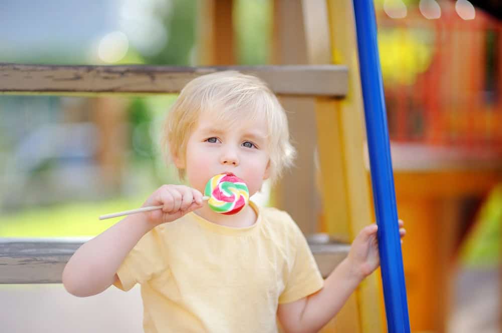 Child with food allergies eating a lollipop at Sesame Place.