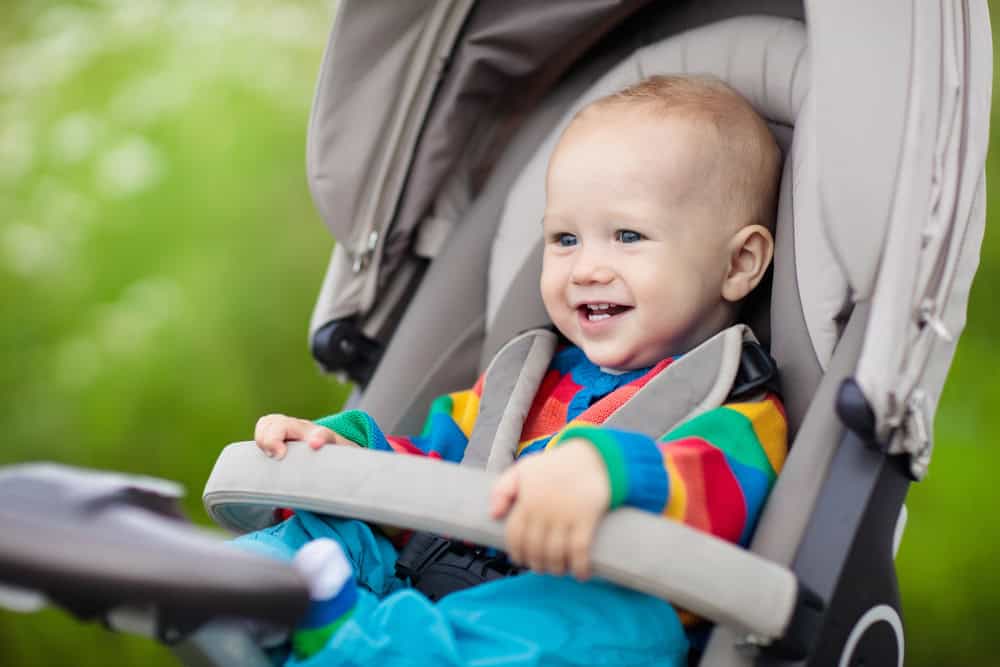 Happy toddler sitting in a stroller at Sesame Place, enjoying a day out.