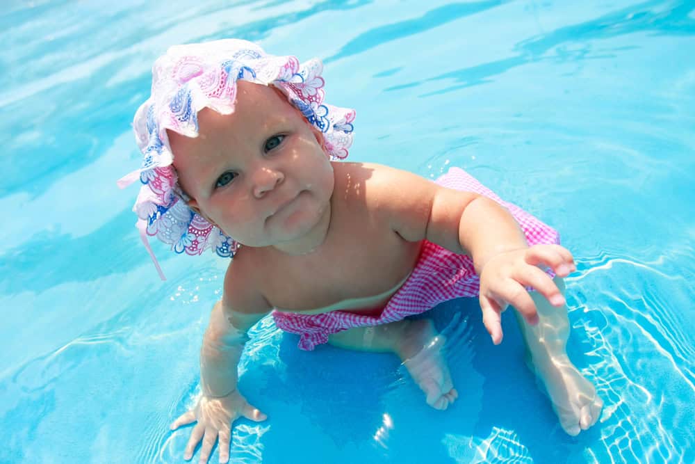  Remove BG Save Share Sample Baby girl in hat sitting in waterpool
