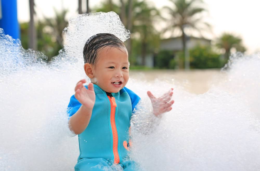 Child enjoying water at Wisconsin Dells waterpark in a blue life jacket.