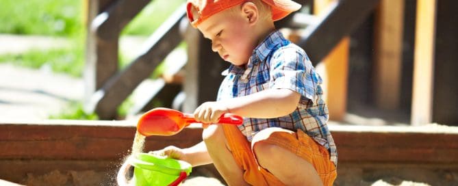 Young Boy Playing In Sandbox At Playground Near Orange County Zoo.