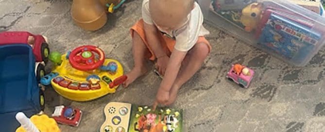 Child playing with colorful toys on a carpeted floor.
