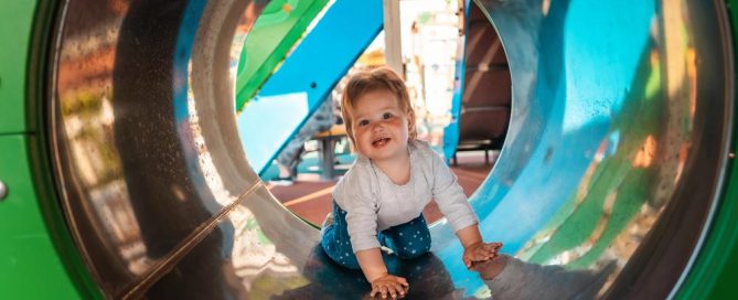 Baby Crawling Through Colorful Playground Tunnel For Kids.