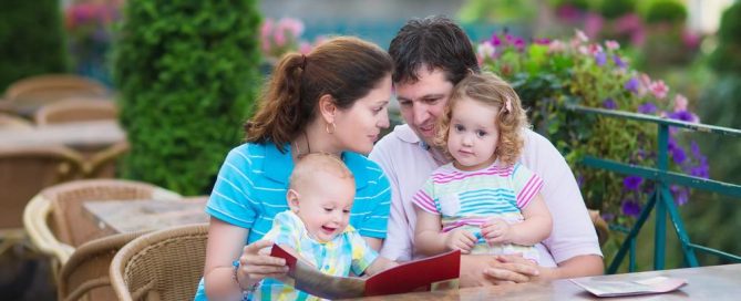 Family Enjoying Outdoor Meal At A Restaurant With Children And Parents.