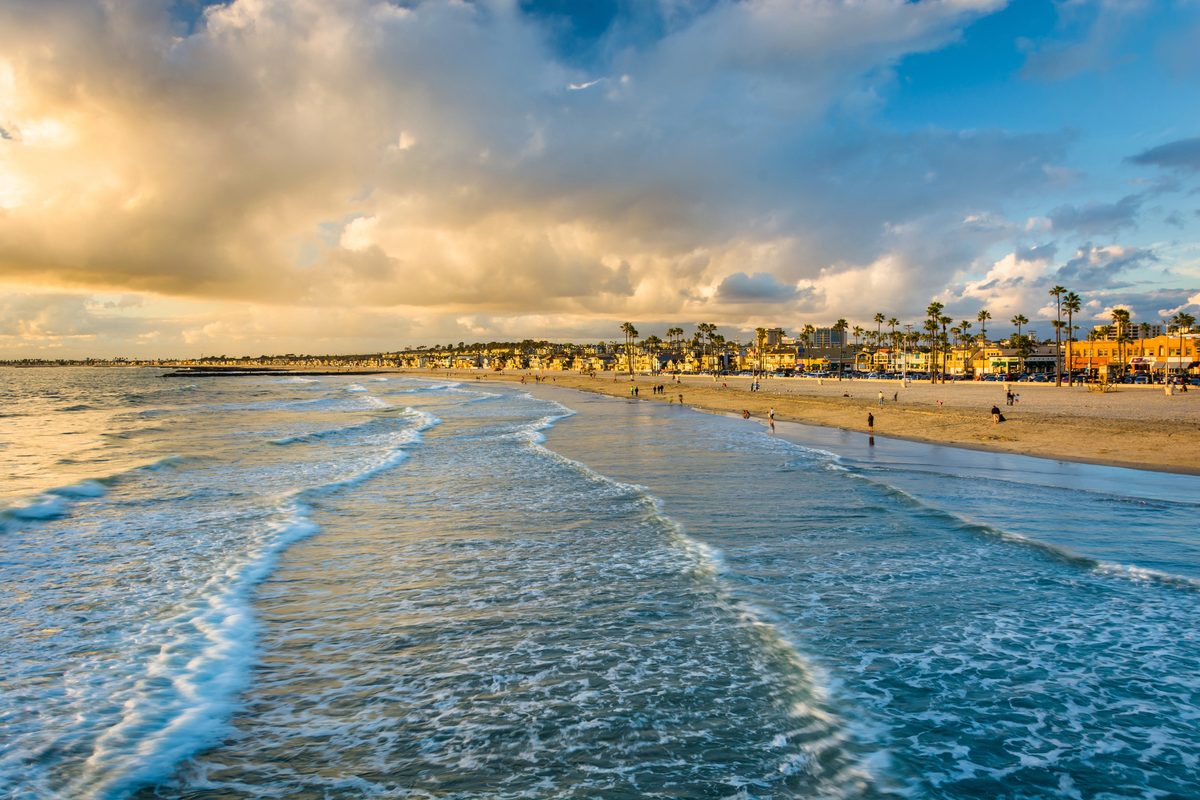 Golden Evening Light Over A Wide Sandy Orange County Beach With Gentle Waves