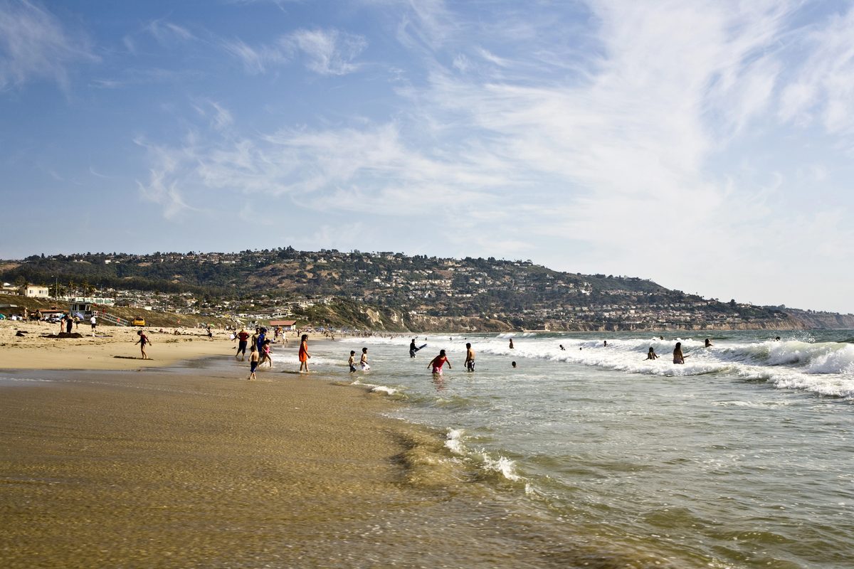 Families Playing In Gentle Surf On A Sunny Day, A Beach Scene For Planning Redondo Beach With Toddlers
