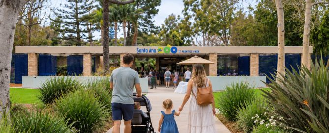 Family With A Stroller Walking From Santa Ana Zoo Parking Toward The Zoo Entrance