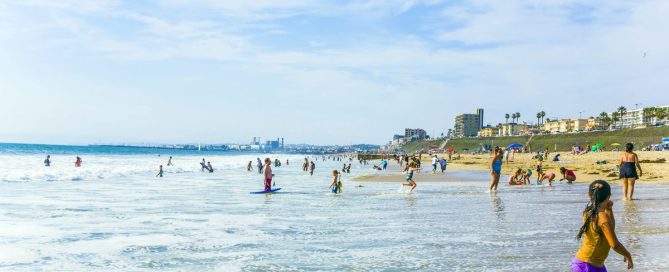 Families Playing In The Shallow Surf On A Sunny Redondo Beach Day Near Seaside Lagoon