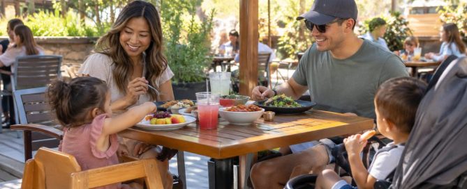 Family Sharing A Meal On A Sunny Patio At One Of The Toddler-Friendly Restaurants Near The Santa Ana Zoo