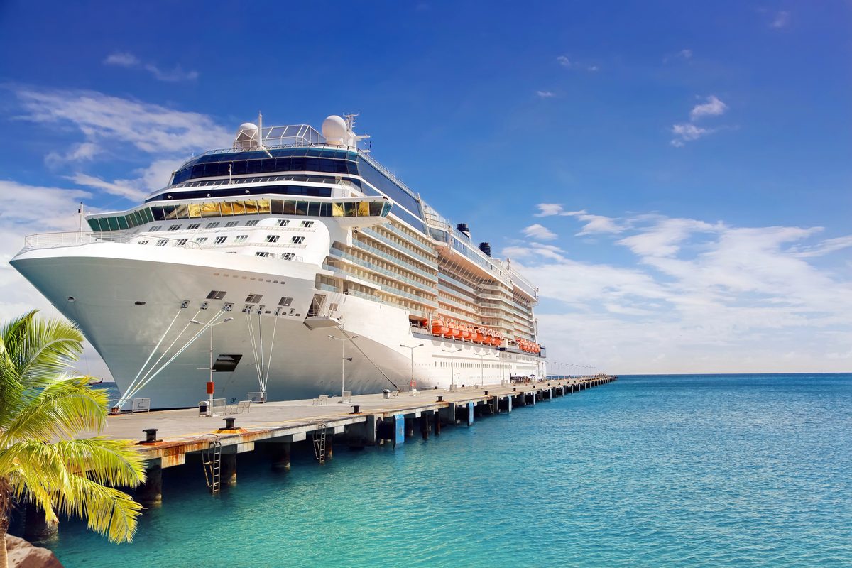 White Cruise Ship Docked At A Pier Beside Turquoise Water On A Sunny Day
